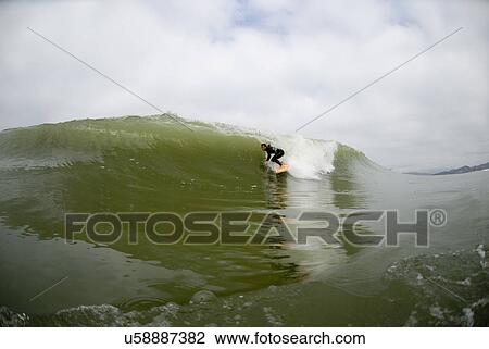 Stock Image - A male surfing. Fotosearch