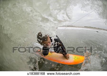 Stock Photo - A male surfing. Fotosearch