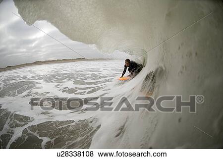 Stock Photo - A male surfing. Fotosearch