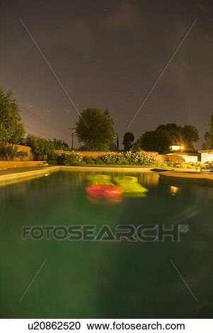 Stock Image - A pool lite up at night. Fotosearch
