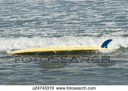 Stock Photo - A surfboard floating upside down. Fotosearch