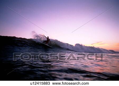 Stock Image - A surfer doing a turn at sunset. Fotosearch