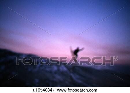Stock Photo - A surfer doing an air at sunset. Fotosearch