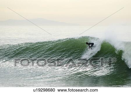 A surfer drops into a huge wave during a swell that hit Southern California View Large Photo Image Stock Image - A surfer drops into a huge wave during a swell that hit Southern California. Fotosearch