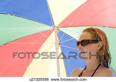 A young female under a colorful umbrella View Large Photo Image Stock Photograph - A young female under a colorful umbrella. Fotosearch
