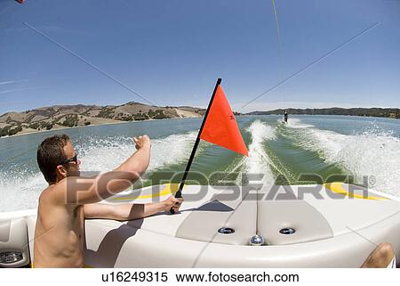 A young male raising a flag on a boat View Large Photo Image Stock Photography - A young male raising a flag on a boat. Fotosearch