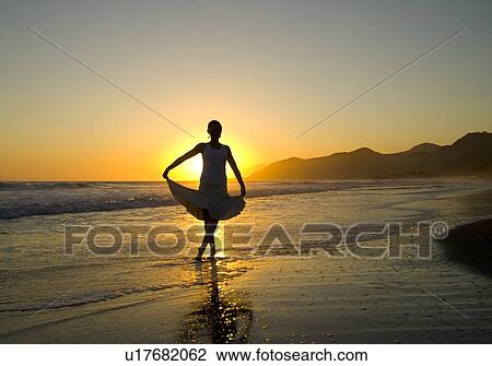 A young woman dances ballet on the beach at sunset View Large Photo Image Stock Image - A young woman dances ballet on the beach at sunset. Fotosearch