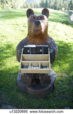 Stock Photography - Bear statue holding box of golf tees. Fotosearch