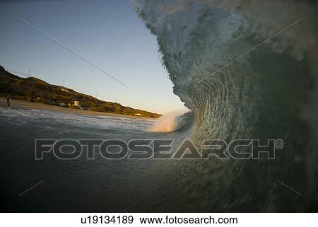 Stock Photo - Breaking waves at sunset. Fotosearch