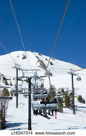 Picture - Chairlift carrying skiers up the mountain. Fotosearch