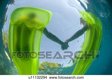 Couple on two green rafts holding hands View Large Photo Image Picture - Couple on two green rafts holding hands. Fotosearch