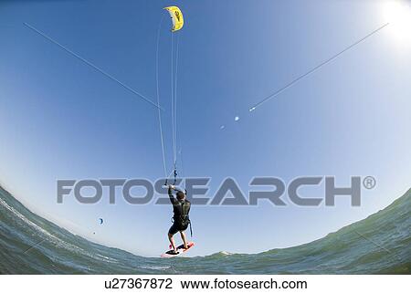 Stock Image - Extreme kite surfer in the air. Fotosearch