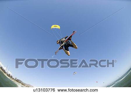 Stock Photograph - Extreme kite surfer in the air. Fotosearch