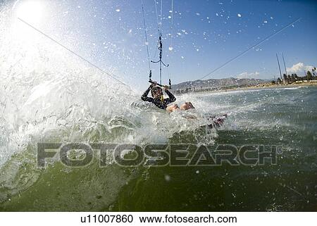 Stock Image - Extreme kite surfer in the water. Fotosearch