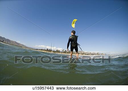 Stock Image - Extreme kite surfer in the water. Fotosearch