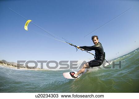 Stock Image - Extreme kite surfer in the water. Fotosearch