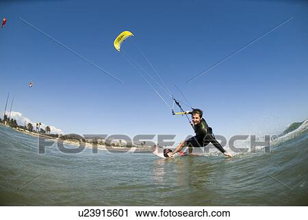 Stock Image - Extreme kite surfer in the water. Fotosearch