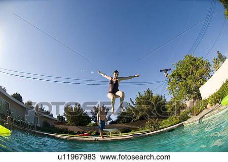 Female diving into an outdoor home pool View Large Photo Image Stock Image - Female diving into an outdoor home pool. Fotosearch