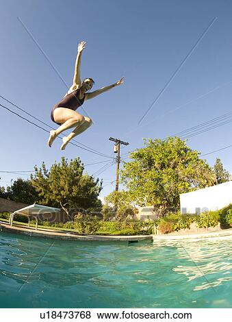 Stock Photo - Female diving into an outdoor home pool. Fotosearch