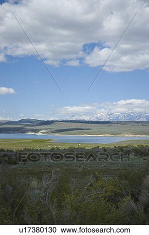 Lake with snow covered mountains in the background View Large Photo Image Stock Image - Lake with snow covered mountains in the background. Fotosearch