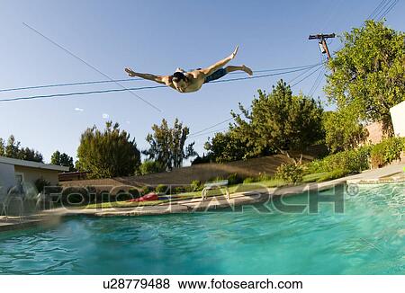 Stock Photo - Male diving into a outdoor home pool. Fotosearch