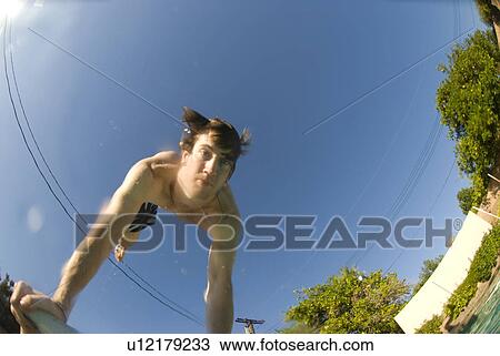 Stock Image - Male diving into a pool. Fotosearch