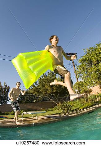 Male diving into an outdoor home pool View Large Photo Image Stock Image - Male diving into an outdoor home pool. Fotosearch