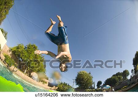 Stock Photograph - Male diving into an outdoor home pool. Fotosearch