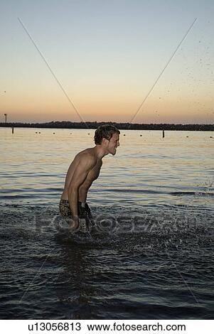 Male in the water after sunset View Large Photo Image Stock Image - Male in the water after sunset. Fotosearch
