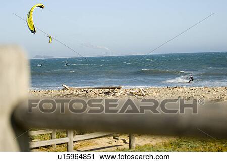 Stock Image - Male kite surfing in the water. Fotosearch