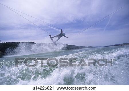 Stock Image - Male wake boarding doing an air. Fotosearch