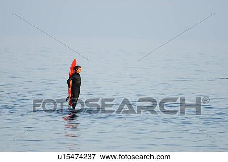 Male with a red surfboard View Large Photo Image Stock Photo - Male with a red surfboard. Fotosearch