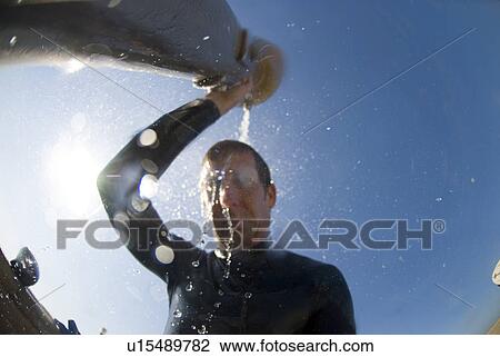 Man in wetsuit pouring water on his head View Large Photo Image Stock Image - Man in wetsuit pouring water on his head. Fotosearch