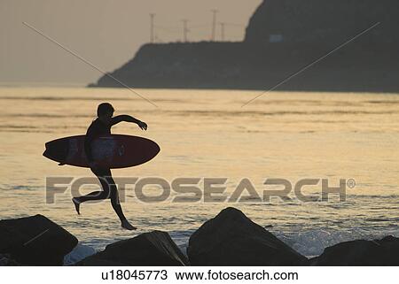 Man with surfboard jumping View Large Photo Image Stock Image - Man with surfboard jumping. Fotosearch