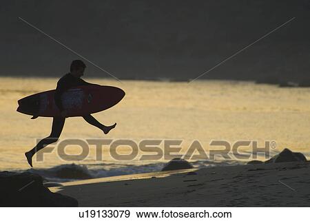 Man with surfboard jumping View Large Photo Image Stock Photo - Man with surfboard jumping. Fotosearch