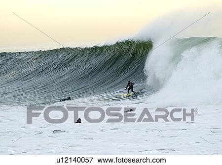 Stock Photo - Professional surfer riding a huge wave. Fotosearch