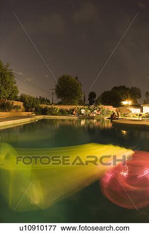 Rafts floating in a pool at night View Large Photo Image Stock Photo - Rafts floating in a pool at night. Fotosearch