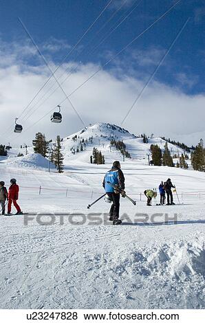 Stock Photo - Skiiers at the base of ski hill. Fotosearch