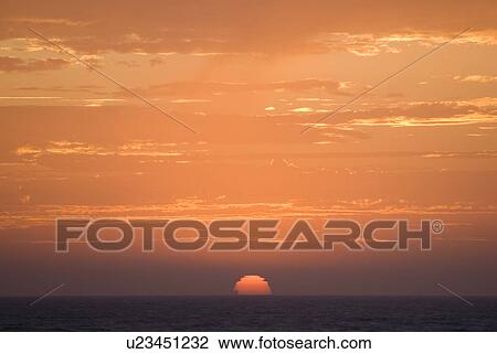 Sunset setting in the ocean View Large Photo Image Stock Image - Sunset setting in the ocean. Fotosearch