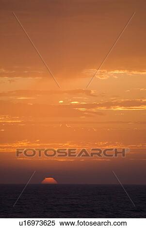 Sunset setting in the ocean View Large Photo Image Stock Photography - Sunset setting in the ocean. Fotosearch