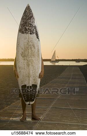 Picture - Surfer behind his board. Fotosearch