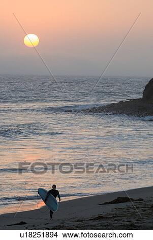 Surfer coming in at the end of the day View Large Photo Image Picture - Surfer coming in at the end of the day. Fotosearch