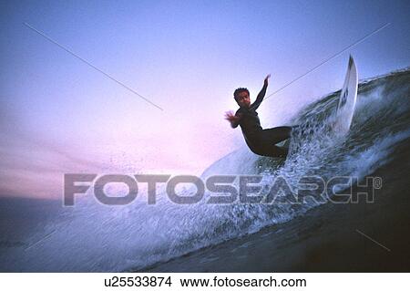 Surfer does an off the lip at sunset View Large Photo Image Picture - Surfer does an off the lip at sunset. Fotosearch