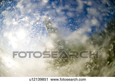 Stock Image - Surfer splashing the camera. Fotosearch