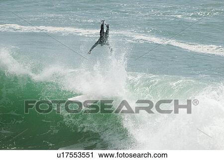 Stock Image - Surfer surfing and wiping. Fotosearch
