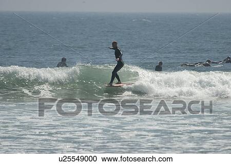 Surfers in the water View Large Photo Image Stock Image - Surfers in the water. Fotosearch