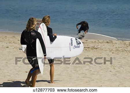 Surfers on the beach View Large Photo Image Stock Image - Surfers on the beach. Fotosearch