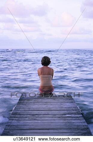 Woman sitting on a pier View Large Photo Image Stock Image - Woman sitting on a pier. Fotosearch