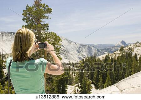 Woman taking picture of mountains View Large Photo Image Stock Photograph - Woman taking picture of mountains. Fotosearch