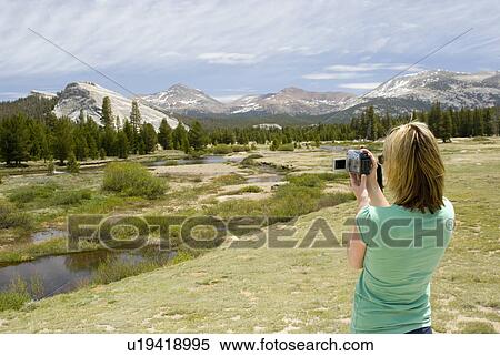 Woman taking picture of mountains View Large Photo Image Stock Photography - Woman taking picture of mountains. Fotosearch